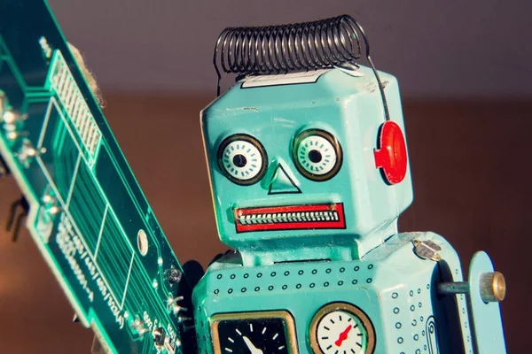 Angry Vintage Tin Toy Robot Carries Green Computer Circuit Board — Stock Photo, Image