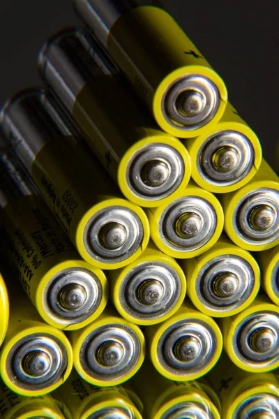 Stack of yellow AA batteries close up, electrical energy storage concept