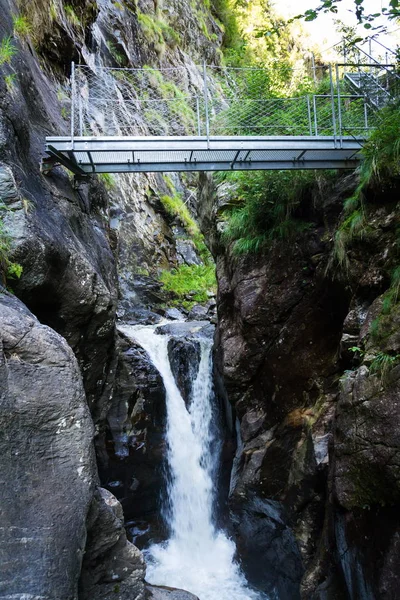 Footbridge on alpine trail through Hell gorge canyon with Riesach waterfalls from lake Riesachsee near Schladming, Austria