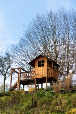 DIY ahşap playhouse swing ve güneşli bir günde bir yamaca slayt olan çocuklar için