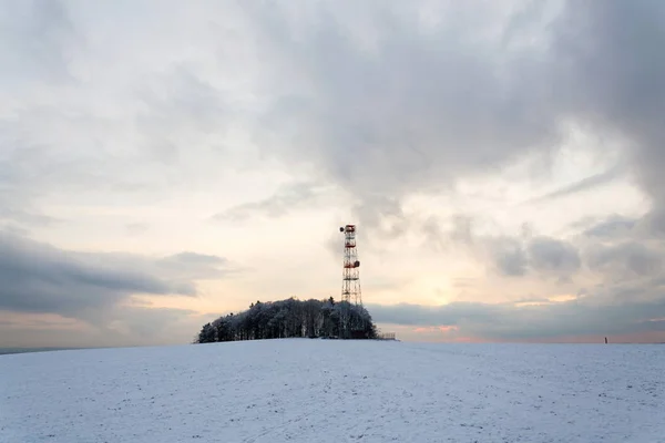 Verici Gün Batımı Sırasında Kırmızı Beyaz Telekomünikasyon Kulede Karlı Kış — Stok fotoğraf