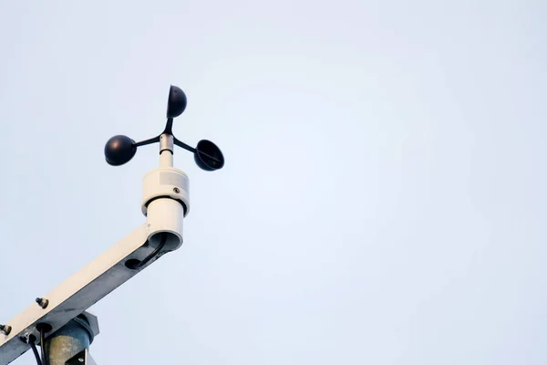 Weather station for meteorological forecast on blue clear sky background, anemometer, wind meter and direction sensors