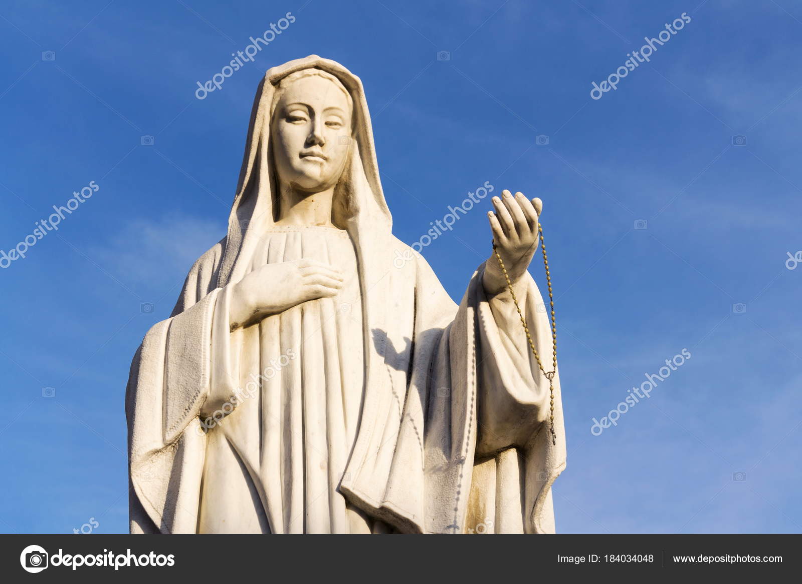 Estatua Virgen María Sosteniendo Rosario Mano Con Fondo Azul Claro — Foto  de stock #184034048 © josekube, image size:1600x1167