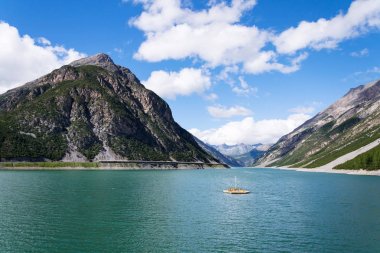 Güzel ahşap iskele banklar ve şezlonglar Lago di Livigno boynuz Brusadella Dağı üzerinde arka planda, Livigno, İtalya, güneşli yaz günü yüzen