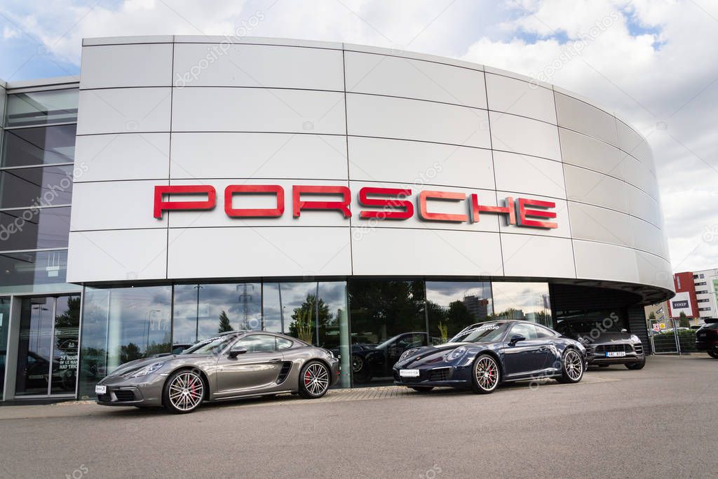 PRAGUE, CZECH REPUBLIC - SEPTEMBER 22 2018: Porsche logo on car in front of dealership building on September 22, 2018 in Prague, Czech Republic.