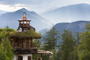 Güzel gün batımı Dachstein dağlar üzerinde dramatik bulutlar ile yeşil çimen ile ahşap uyanık çatı ön planda, Kuzey kireçtaşı Alpler, Schladming, romantik aşk huzurlu meditasyon kavramı