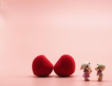 Pembe arka plan duvar kağıdında tomurcukların ortasında iki kırmızı kalp var. 14 Şubat 'ta öpüşen romantik ve mutlu aşıklar. Düğün ve nişan için Sevgililer Günü' nüz kutlu olsun.