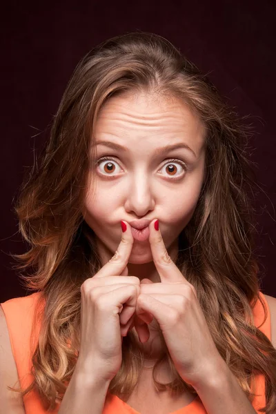 Girl grimaces on a dark background. Close-up. — Stock Photo, Image