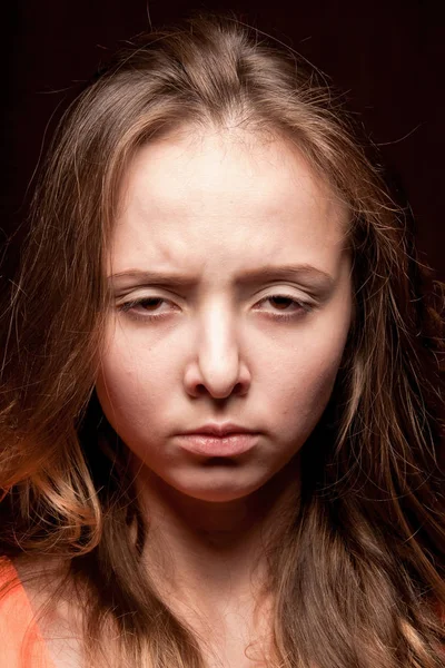 Tired angry girl on a dark background. — Stock Photo, Image