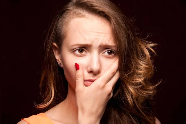Closeup of girl experiencing a toothache, on a dark background. — Stock Photo, Image