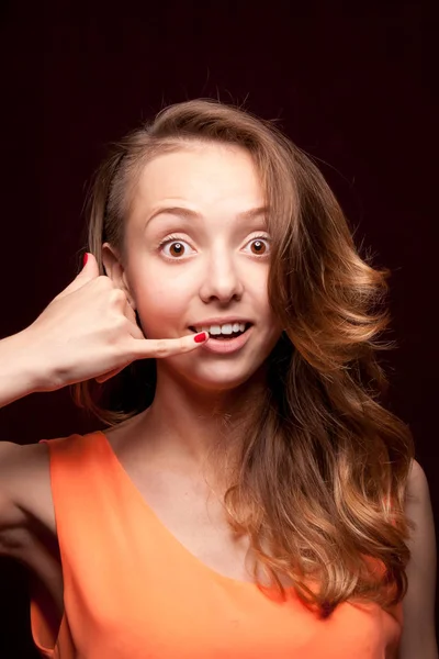 Surprised girl makes a gesture with her hand call, on a dark bac — Stock Photo, Image