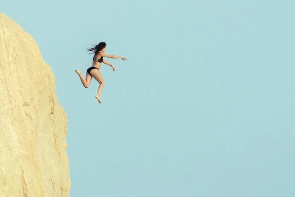 Girl jumping in the air near the cliff. — Stock Photo, Image