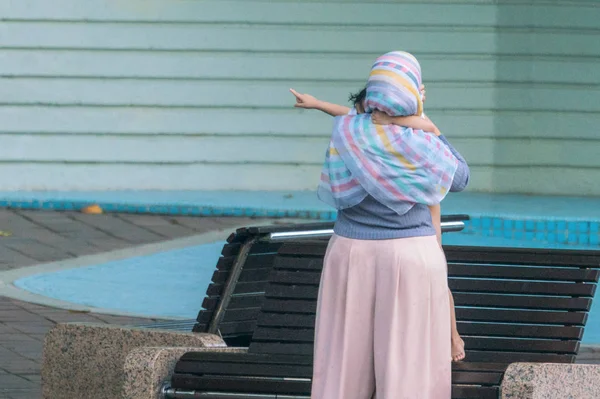 Une femme avec un bébé dans les bras. Vue de l'arrière . — Photo