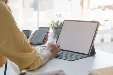 Kafe dükkanında akıllı telefonu tabletle kullanan bir iş kadını. akıllı telefon veya cep telefonu ile boş ekran ve eklenebilir metin veya otahers, teknoloji konsepti