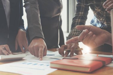 İş kadını elinde kalem ve grafik kağıtlarıyla gelecek yıl belirlenen hedeflere ulaşmak için satışları planlamak üzere toplanıyor.