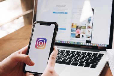 CHIANG MAI, THAILAND - 26 AUG 2018: Bir kadın Kafe 'deki ekranda Apple iPhone X uygulamasını tutuyor. Instagram akıllı telefonlar için fotoğraf paylaşım uygulamasıdır