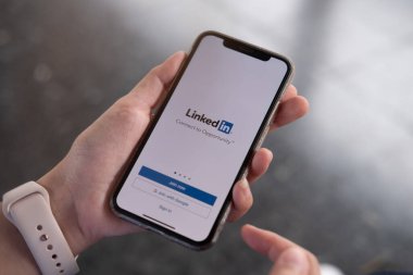 CHIANG MAI, THAILAND, JUL 27, 2019: Bir kadın ekranda LinkedIn uygulamalı Apple iPhone X 'leri tutuyor. LinkedIn akıllı telefonlar için bir fotoğraf paylaşım uygulaması