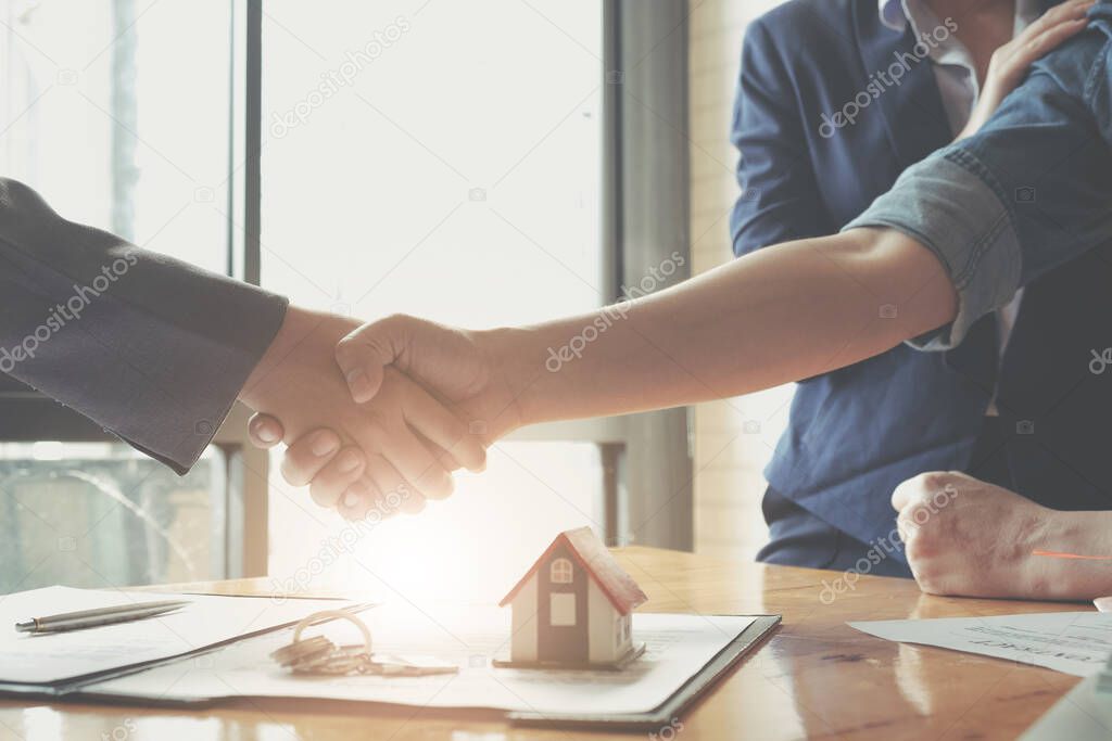Real estate agents agree to buy a home and give keys to clients at their agency's offices. Concept agreemen