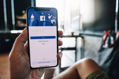 CHIANG MAI, THAILAND - 6 Mayıs 2020: Facebook sosyal medya uygulaması logosu giriş, mobil uygulama ekranı için kayıt sayfası iPhone X 'de (10) kişinin elinde e-ticaret alışveriş otobüsleri üzerinde çalışıyor