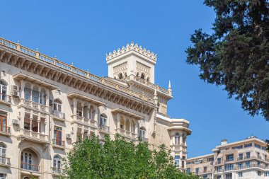 Gökyüzüne karşı kare kuleleri olan büyük, güzel bir bina.