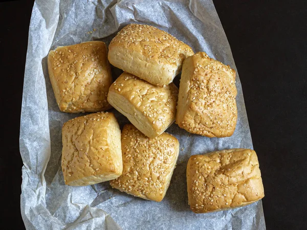 На листе пищевого пергамента золотые миланские булочки с кунжутом — стоковое фото