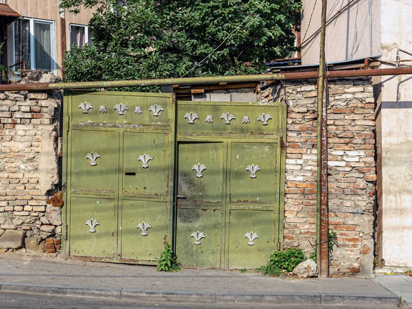 Una vieja puerta verde en una pared de ladrillo áspera — Foto de Stock