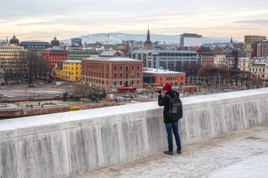 Adam gözlem güvertesinden şehrin ufuk çizgisinin fotoğraflarını çekiyor.