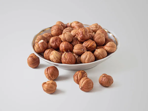 Hazelnuts в небольшой пластины на светлом фоне — стоковое фото