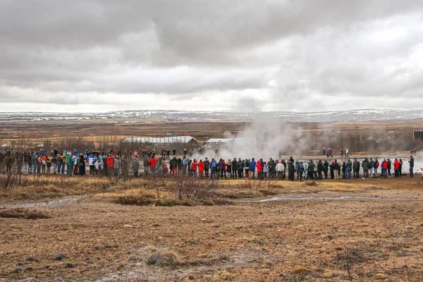 Grupo de turistas esperando una erupción de géiser en Islandia — Foto de Stock