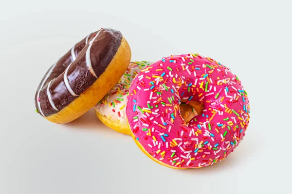 Многоцветные пончики с клубникой, шоколадом и ванильной глазурью — стоковое фото