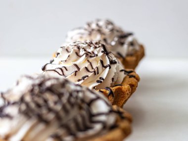 Krem şantili ve çikolata soslu sepetler dolusu kısa hamur işi.