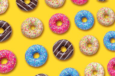 Sarı arka planda çok renkli Amerikan donutları.