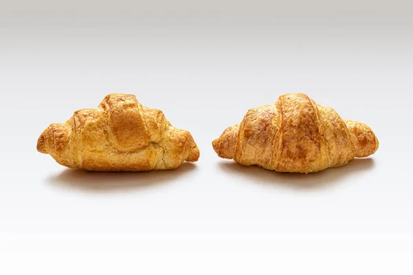 Dwa mini rogaliki z drożdżowego ciasta francuskiego, ze złotą skórką — Zdjęcie stockowe