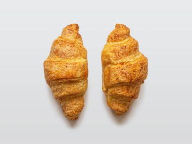 İki mini kruvasan, arka planda altın kabuklu.