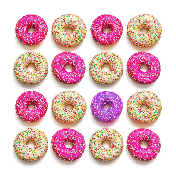 Doughnuts with pink and vanilla icing, are laid out in rows — Stock Photo, Image