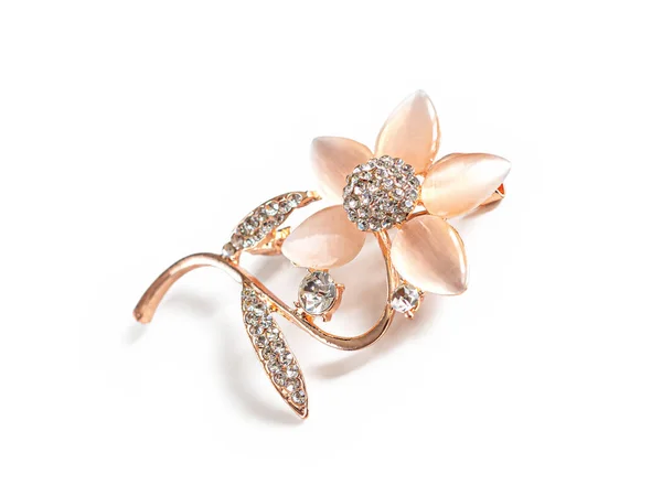Brooch in the form of a flower with petals of pink mineral and faceted transparent stones, isolated on a white background. Costume jewelry and jewelry