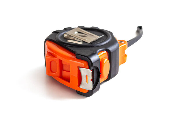 The body of the measuring tape is made of black and orange plastic, isolated on a white background