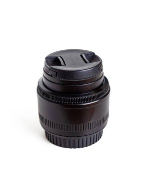 Lensin ön camını korumak için koruyucu bir kapağı olan fotoğraf merceği, beyaz arka planda izole edilmiş.