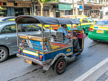 Bangkok, Tayland, 10.09.2015. Bangkok caddesinde akşam trafiğinde taksisine binen bir şoför.