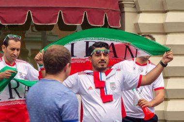 Moskova, Rusya, 12 / 06 / 2018. İran Millî Futbol Takımı tişörtleri giyen erkekler, ellerinde bayraklar Kızıl Meydan 'daki GUM mağazasının yanında. İranlı futbol taraftarları