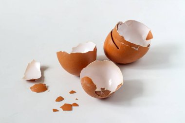 Açık arkaplanda kırılmış kahverengi yumurta kabuğu.