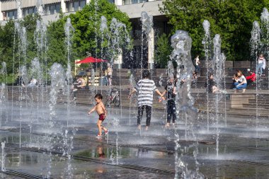 Moskova, Rusya, 05.08.2018. Yetişkinler ve çocuklar müze parkındaki kuru bir çeşmede banyo yapıyorlar.