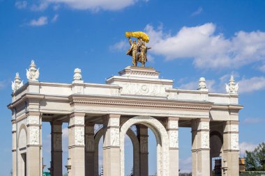 Moskova, Rusya, 05.03.2018. Stalin İmparatorluğu tarzında yapılmış VDNKH 'nin ana girişinin kemeri. Serginin ana sembolünün üzerinde bir traktör sürücüsü ve kolektif çiftçi heykeli (kadın) bulunur.)