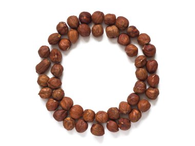 Fındık çekirdekleri beyaz arkaplanda izole edilmiş bir daire şeklinde serilmiştir.