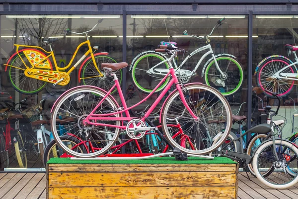 自転車ショーケースの前にはピンクの自転車を先頭に木製の台座が立っています レンタサイクル — ストック写真