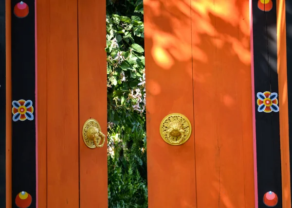 Bhutan-style orange  door with golden knocker