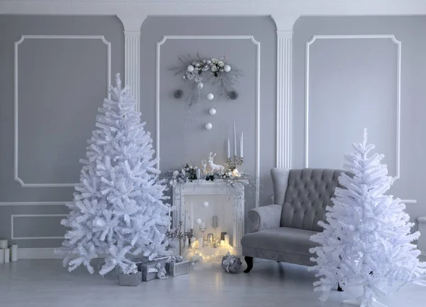 Güzel beyaz arka planda Noel süsleri. Şömine, mumlar ve kocaman beyaz Noel ağacı..