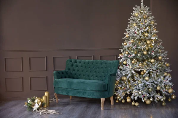 Fotoğraf stüdyosunda Noel süslemeleri. Yeşil lüks kanepe ve güzel Noel ağacı.