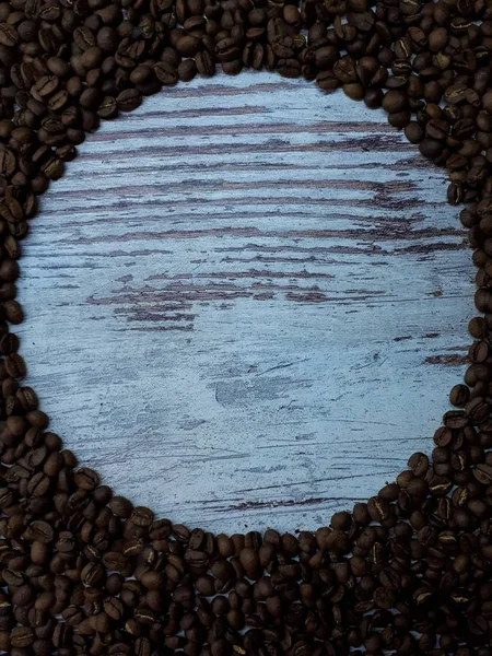 木のテーブルの上の端には 焼きたての茶色の芳香のあるコーヒー豆が乗っています — ストック写真