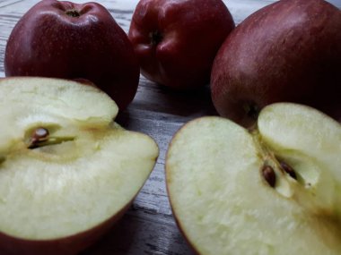 Yakın plan kırmızı, sulu organik, lezzetli elmalar ahşap bir masa arkasında.